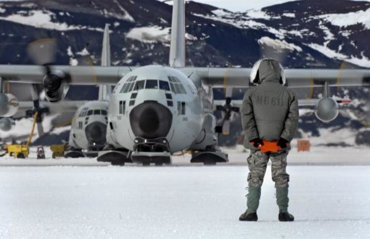 Tech. Sgt. Kevin Call waits to marshal an LC-130 Hercules from its parking spot on the annual sea ice runway near McMurdo Station, Antarctica in 2007. LC-130s are equipped with skis and wheels so they can land on Antarctica's sea ice runways.