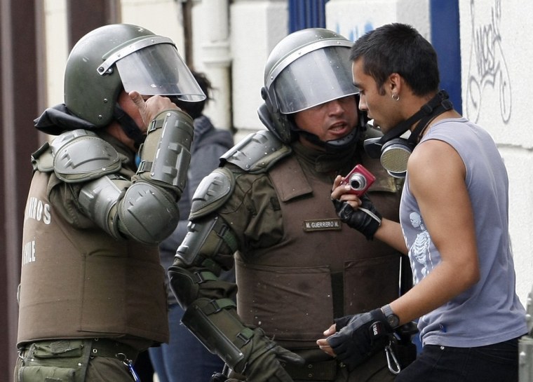 Image: Riot police harass a student holding a camera during a protest against the government to demand changes in the public state education system in Valparaiso city