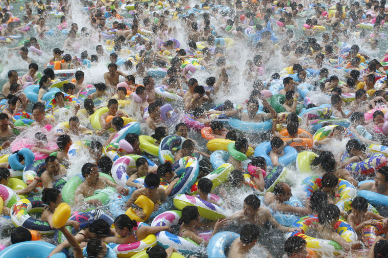 Image: Residents crowd in a swimming pool to escape the summer heat during a hot weather spell in Daying county of Suining