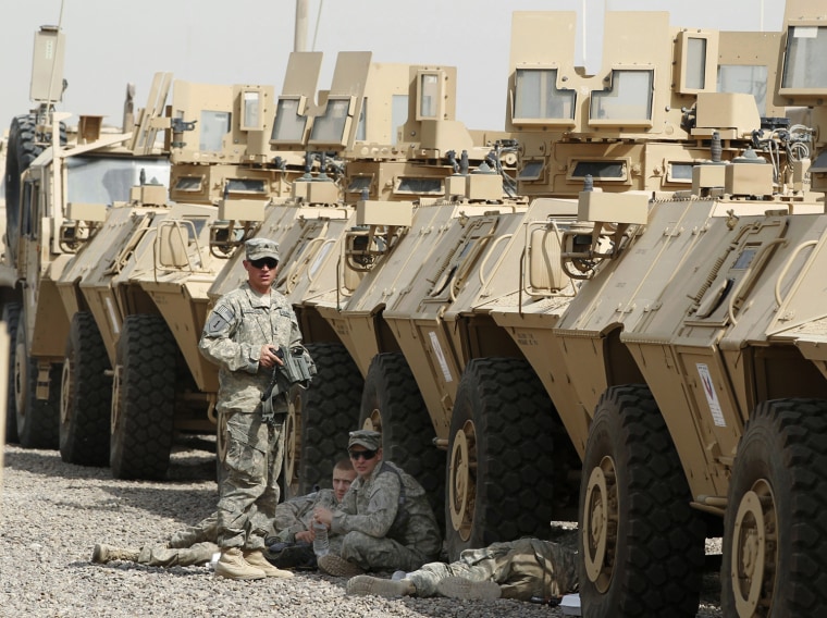 Image: U.S. soldiers take a rest in the shade of armoured vehicles at Camp Liberty in Baghdad