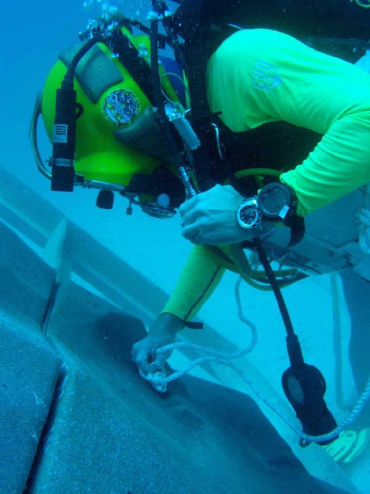 A diver anchoring to a simulated asteroid surface created for NASA's underwater NEEMO 15 mission.