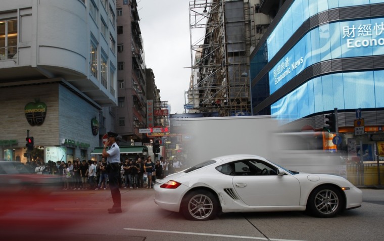 Image: Cars cross a street in Mong Kok district in Hong Kong