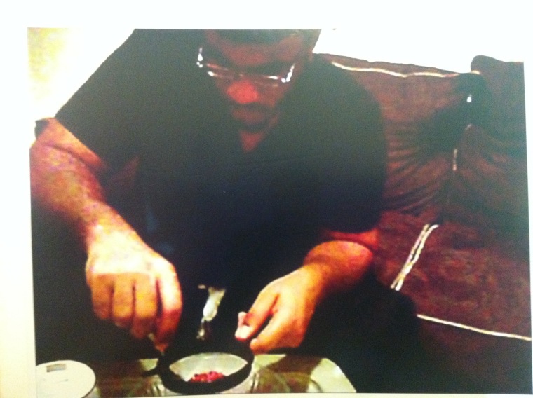 This New York Police photo, displayed at Mayor Michael Bloomberg's news conference, Nov. 20, shows Jose Pimentel inside his apartment, taking material off matches to build a pipe bomb, according to Police Commissioner Ray Kelly.