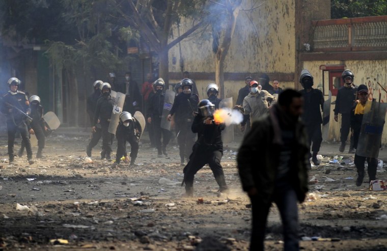 Image: An Egyptian riot police officer fires tear gas during clashes with protesters near Tahrir square in Cairo