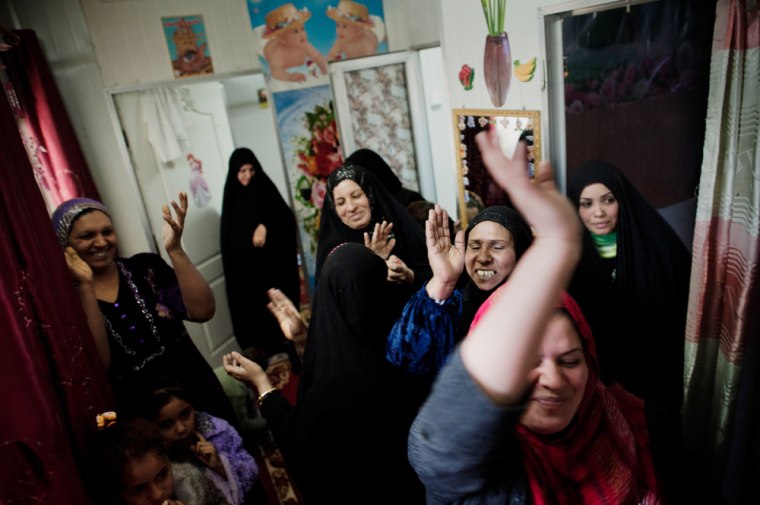 Image: Women at a government-run trailer camp for widows celebrate a resident's marriage.