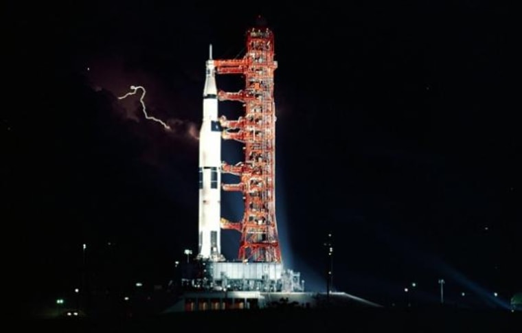 Lightning flashes in the sky behind the Saturn V rocket that will propel Apollo 15 to the moon, July 25, 1971.