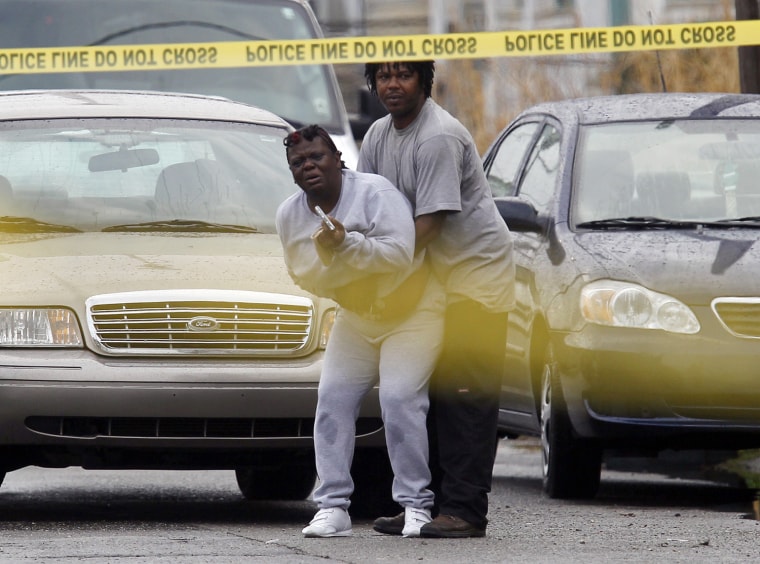 A bystanders identified as the victim's mother cries at the scene of a murder on the corner of Sixth and Danneel Streets on Jan. 25, 2011.
