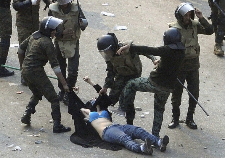 Image: Egyptian soldiers arrest a female protester during clashes in Cairo's Tahrir Square on Saturday