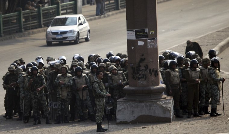 Image: Soldiers stand guard after clashes with protesters at Tahrir Square in Cairo on Saturday