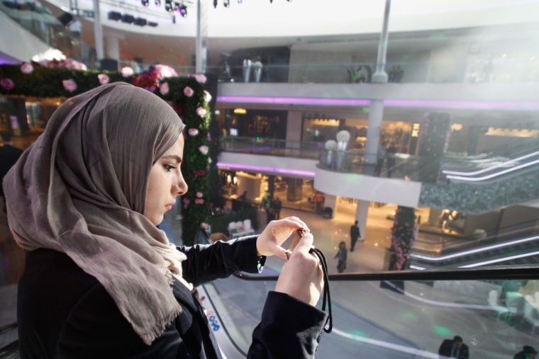 Image: A woman takes photographs at a new shopping mall, Casablanca, Morocco