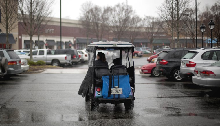Image: driver in golf cart looking for a parking spot