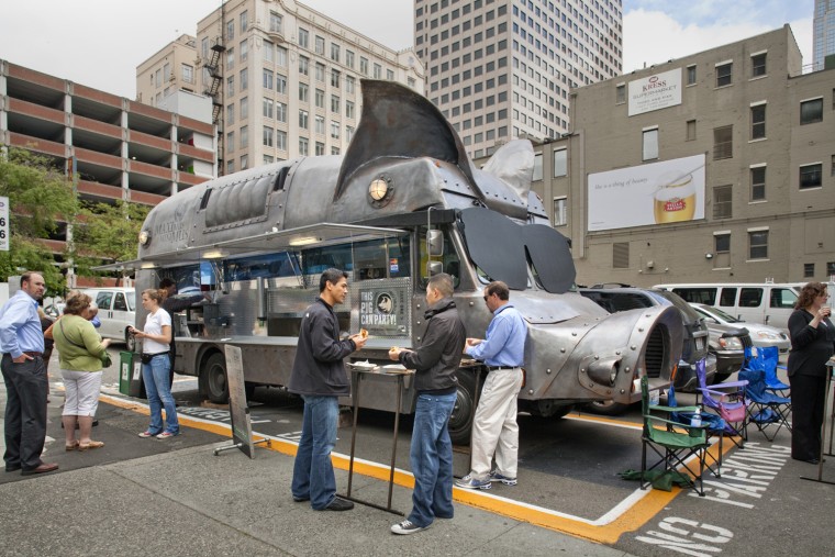Oliver Murillo and Alan Hong eat lunch at the Maximus Minimus pig-shaped food truck in downtown Seattle. 