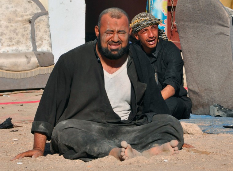 Image: Iraqi residents grieve at the site of a bomb attack in Nassiriya