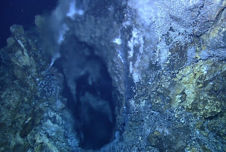 A shimmer of superheated fluid gushes from an opening some 3 feet (1 meter) across near the top of a hydrothermal vent deep in the Caribbean. Researchers are returning to the intriguing site, and one of its deeper and more mysterious neighbors, to sample them for the first time.