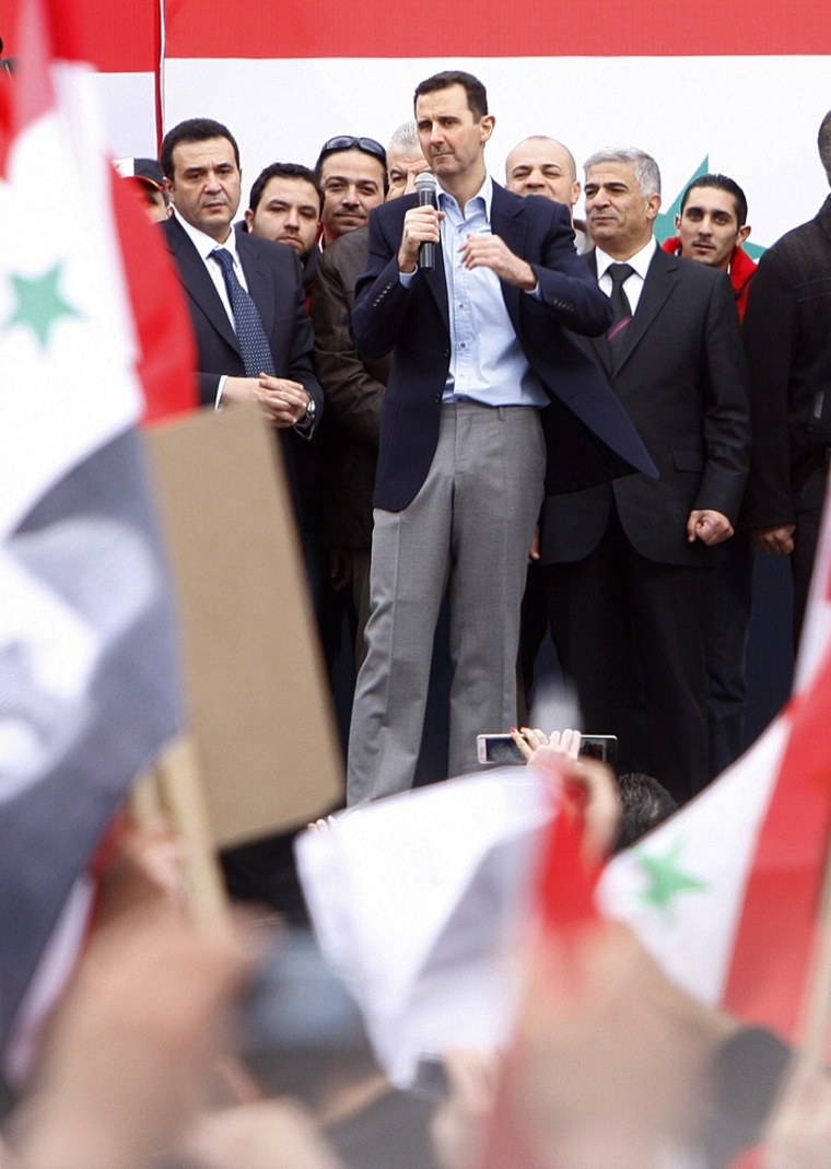 Image: Syrian President Bashar Assad, center, addresses supporters during a rally at a central square in Damascus, Syria