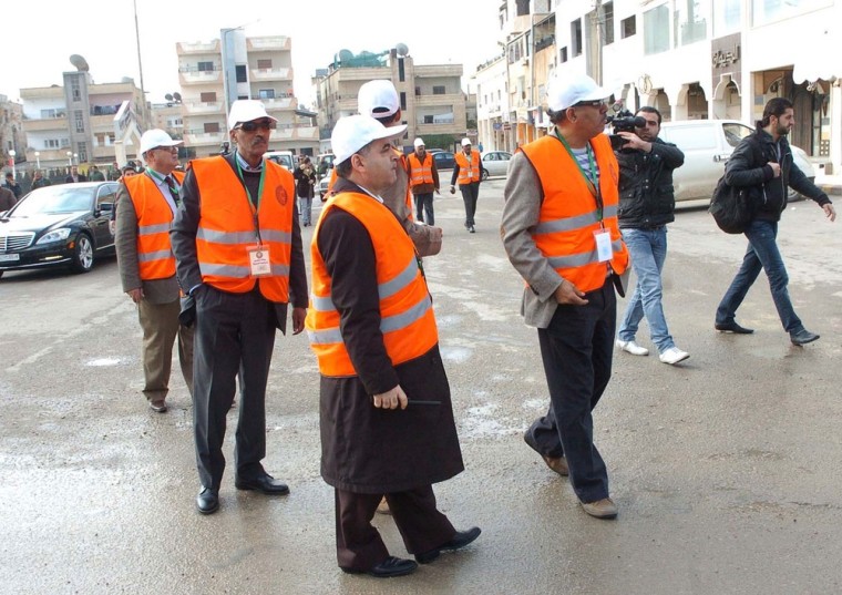 Image: In this photo released by Syria's official news agency, Arab League monitors check Al-Sabil area, in Daraa, Syria
