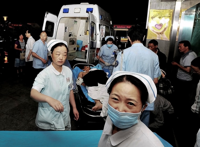 An injured man from a Foxconn factory is carried by medical staff into a hospital in Chengdu, in China's Sichuan province Friday, May 20, 2011