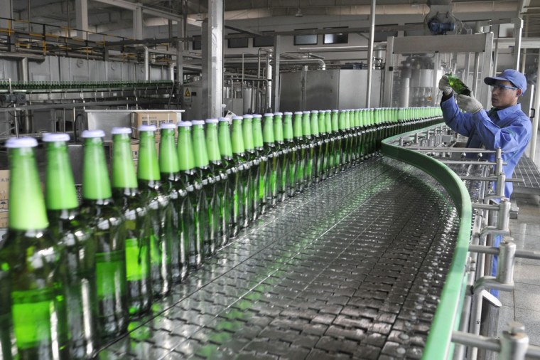 Image: beer on a production line at the Tsingtao brewery in Rizhao, Shandong province, China