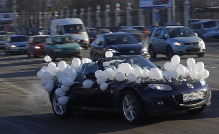 Image: A car decorated of white balloons seen on the Moscow's Garden Ring road during a protest in Moscow