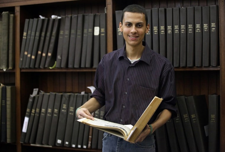 Image: Brown University senior Malcolm Burnley, 22, stands with a copy of the 1961 edition of the Brown University Herald