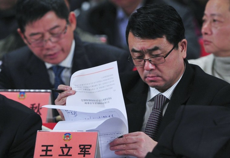 Image: Wang Lijun reads documents as he attends a session of the Chinese People's Political Consultative Conference (CPPCC) last month.