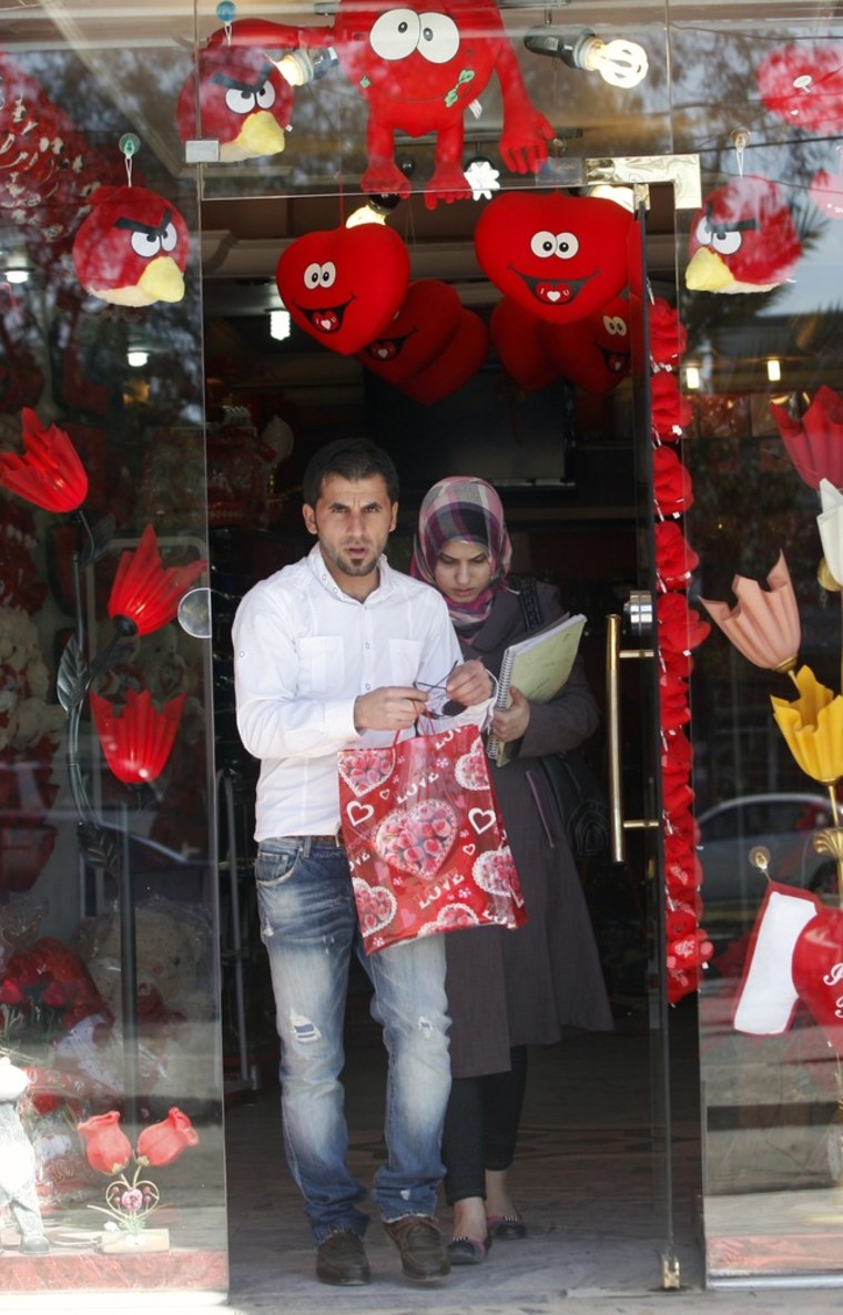 Image: An Iraqi couple leave a shop selling Valentine's Day gifts in Baghdad, Iraq