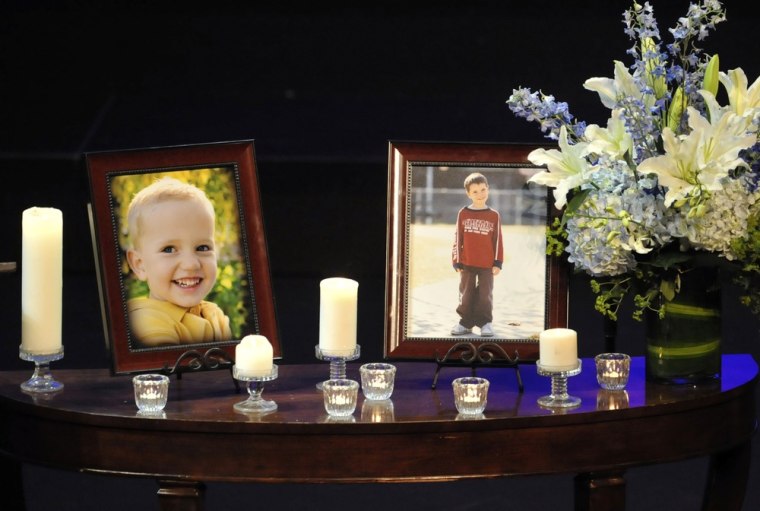 Image: Photographs of Charles and Braden Powell are displayed during their funeral services in Tacoma