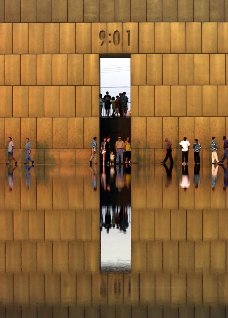 Visitors walk past the east gate of time at the Oklahoma City National Memorial in Oklahoma City