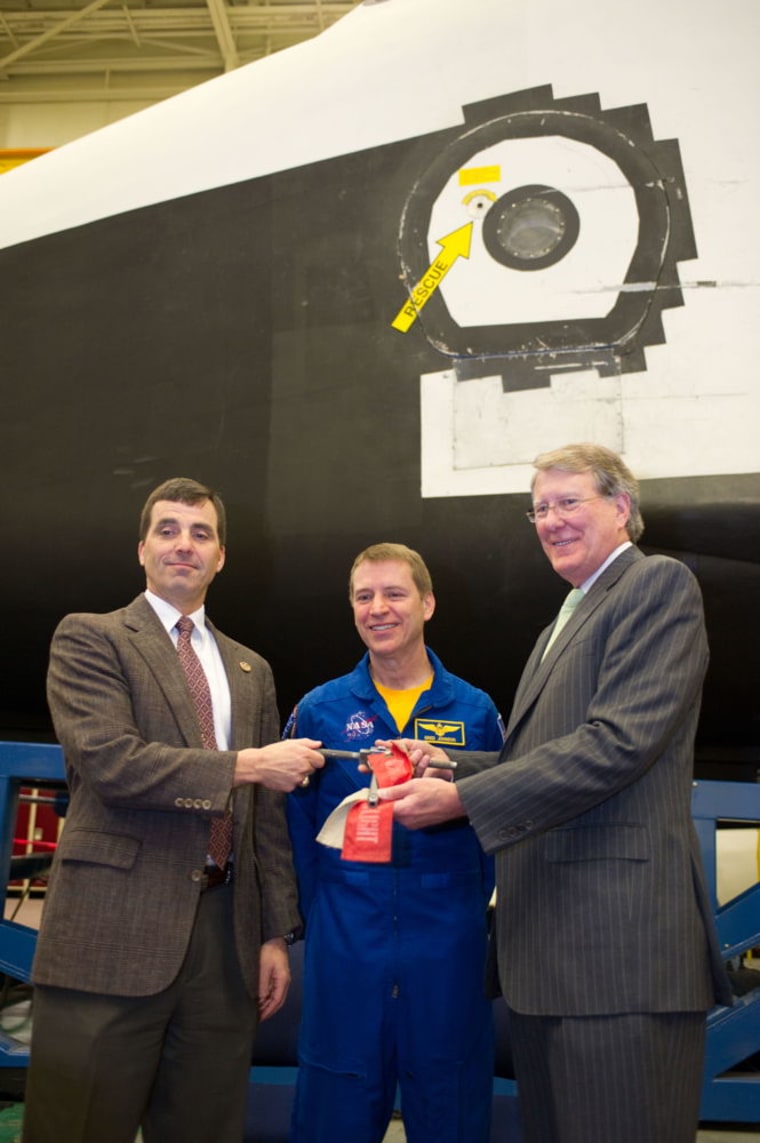 From left to right are NASA's Mission Operations Director Paul Hill, astronaut Gregory C. Johnson and the Museum of Flight’s President Douglas King during a ceremony at the Johnson Space Center last Thursday. The Houston facility officially handed over the “keys” to the space shuttle Full Fuselage Trainer to the Seattle museum.