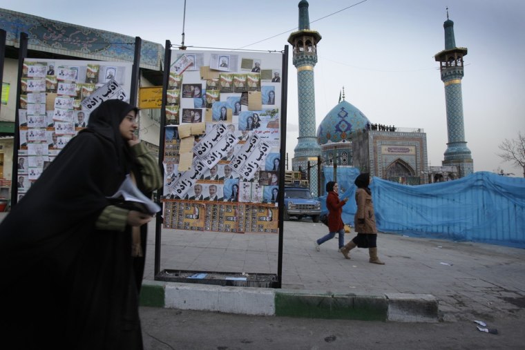 Image: An Iranian woman passes by electoral posters two days ahead of Iran's parliamentary elections