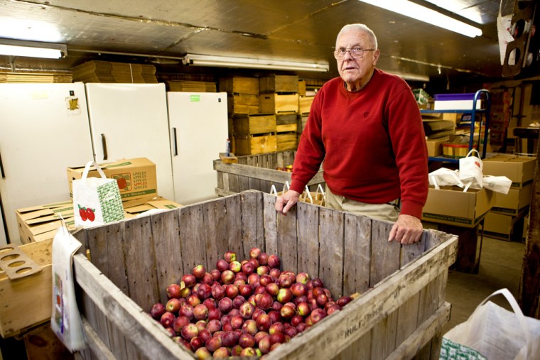 Image: Farmer Bob Rulf in the market building at Rulfs Orchard with some of his recent apple crop.