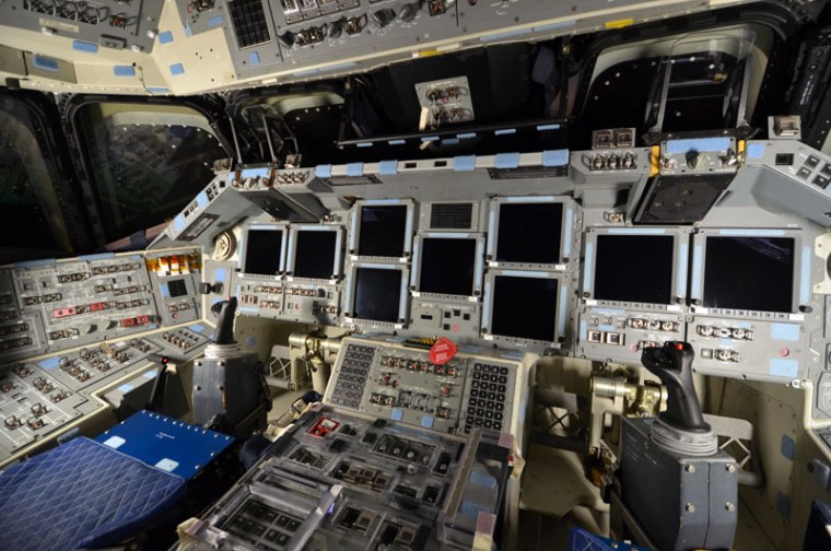Endeavour's forward flight deck: commander's seat at left, pilot's at right. Both positions have manual flight controls, including rotation and translation hand controllers, rudder pedals and speed-brake controllers.