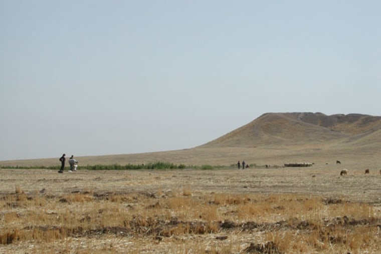Archaeologists inspect the mound at Tell Brak, in northeastern Syria. The 283 million-cubic-foot (8 million-cubic-meter) mound is entirely artificial, accumulating over 6,000 years, as residents built on top of old mud brick buildings.