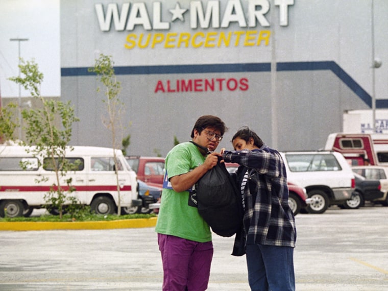Shoppers leave the new Wal-Mart store, the largest in the world, Sept. 30, 1993 in Iztapalapa, a suburb of Mexico City. Mexican consumption of American products and the actual size of the Mexican market is one of the topics that will likely be discussed during the debate between Ross Perot and U.S. Vice President Al Gore on the North American Free Trade Agreement (NAFTA). (AP Photo/Joe Cavaretta)