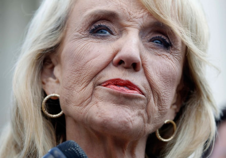 Image: Arizona Governor Jan Brewer speaks to the press outside the U.S. Supreme Court in Washington