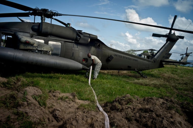 Image: An American task force member refueling a Black Hawk helicopter in Puerto Castilla.