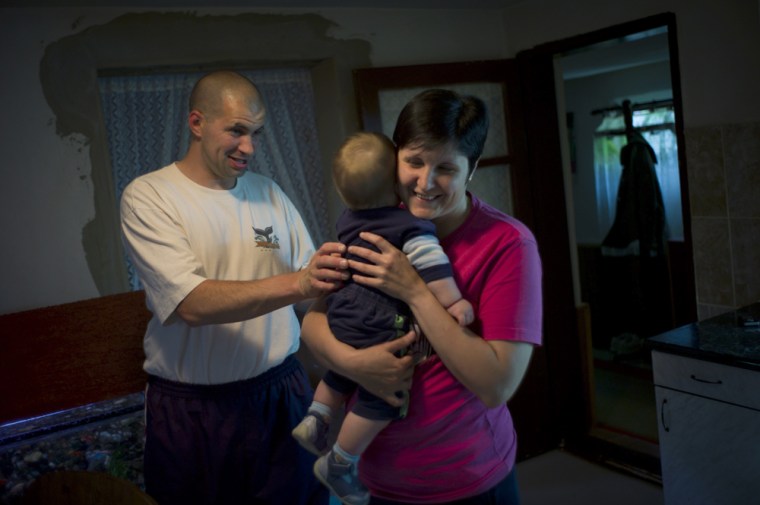 Image: Ervin Balo, left, who tried to sell a kidney to support his family while unemployed, with his wife, Elvira, and one of his children, in Kikinda, Serbia.