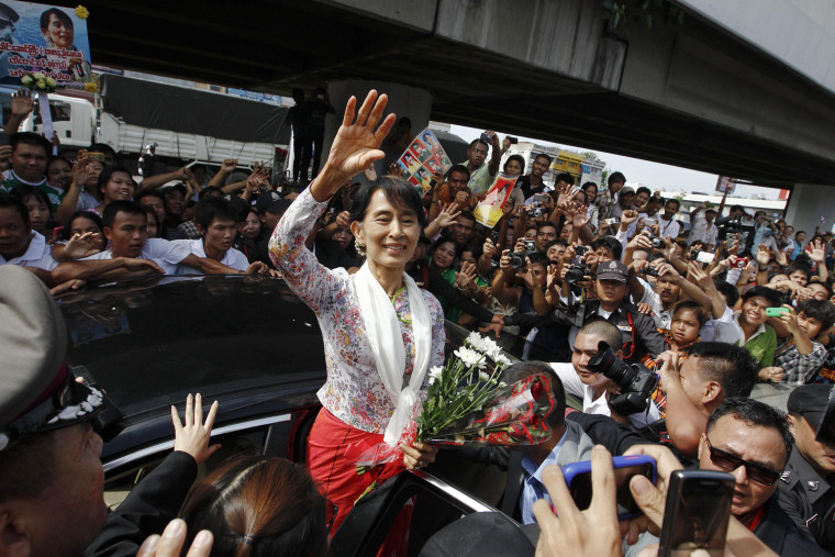 Image: Myanmar's pro-democracy leader Aung San Suu Kyi greets migrant workers from Myanmar, as she visits them in Samut Sakhon province