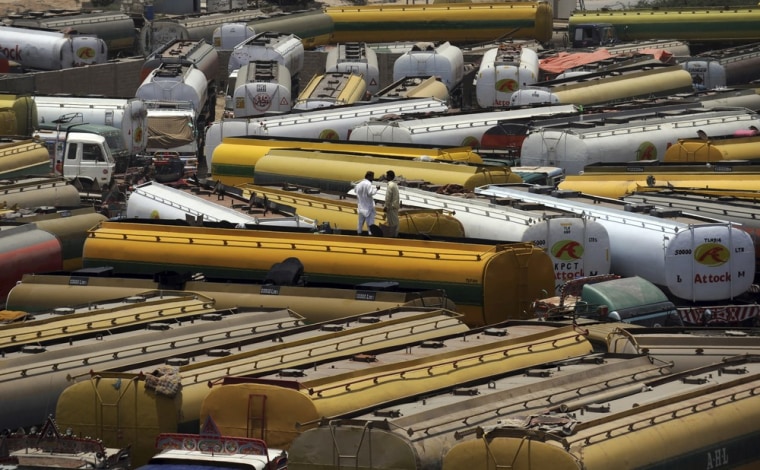 Image: Pakistani drivers stand on top a fuel tanker, used to transport fuel to NATO forces in Afghanistan, parked near oil terminals in Pakistan's port city of Karachi.