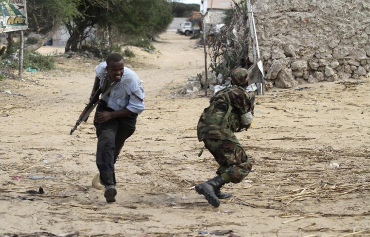 Image: Somali government soldiers run to position during an ambush by al Shabaab rebels on the outskirts of Elasha town