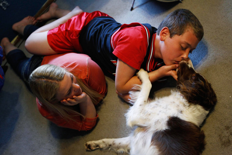 Image: Parker Roos, who suffers from Fragile X, gets a kiss from his dog Daisy as his mother Holly looks on at their home in Canton, Illinois.