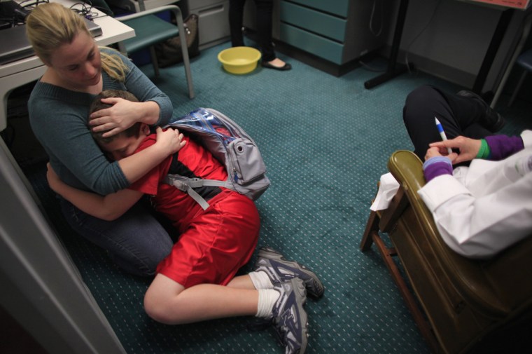 Image: Parker Roos, who suffers from Fragile X, is comforted by his mother Holly during a check up at the Fragile X Clinic and Research Program at Rush University Medical Center in Chicago.