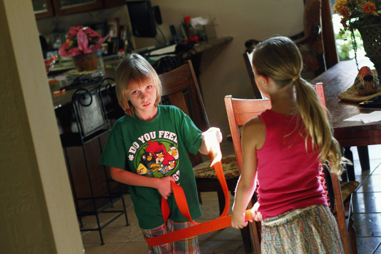 Image: Nine-year-old Jack Balter plays tug-of-war with his sister Brianna at their home in Scottsdale, Arizona.