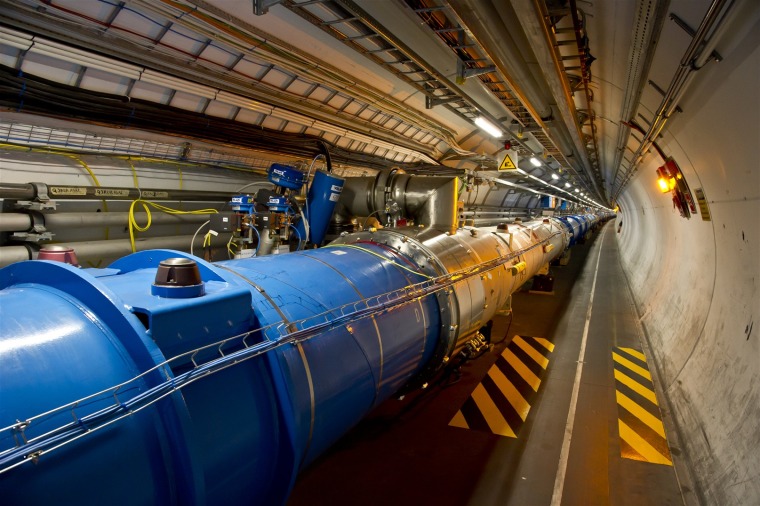 This photo shows the tunnel of the Large Hadron Collider, where beams of particles pass through the central pipes before colliding with each other.