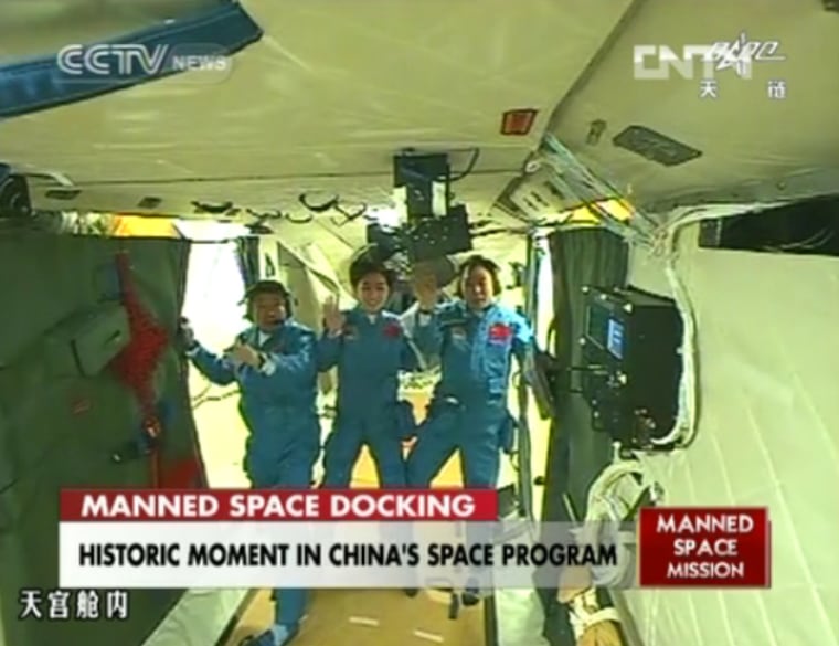 The crew of China's Shenzhou 9 mission waves to a camera aboard the Tiangong 1 space module after successfully docking their capsule at the test module on Monday in this still photo from a state-run TV broadcast on CNTV The crew is, from left, Liu Wang, Liu Yang (China's first female astronaut) and mission commander Jing Haipeng. 
