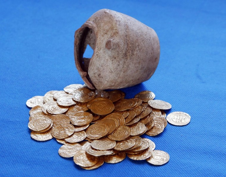 Image: Gold coins and the jar within which they were unearthed during excavations at a Crusader fortress, are displayed near Herzliya