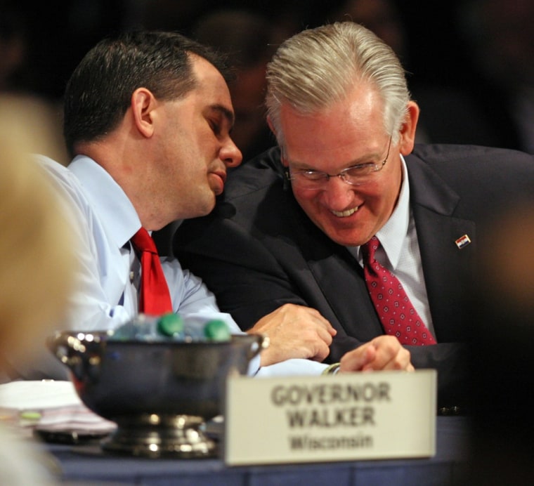 Image: Wisconsin Gov. Scott Walker, left, speaks with Missouri Gov. Jay Nixon, right, during the first full session of the National Governors Association meeting in Williamsburg, Va.