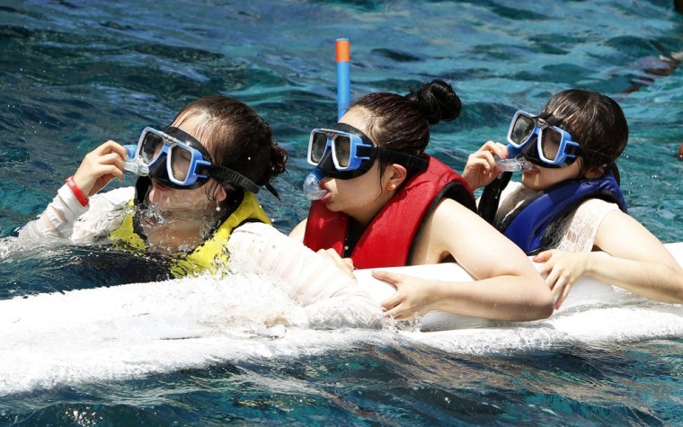 Image: South Korean students of Cebu Pacific International Language school prepare to snorkel during a beach outing in Cebu
