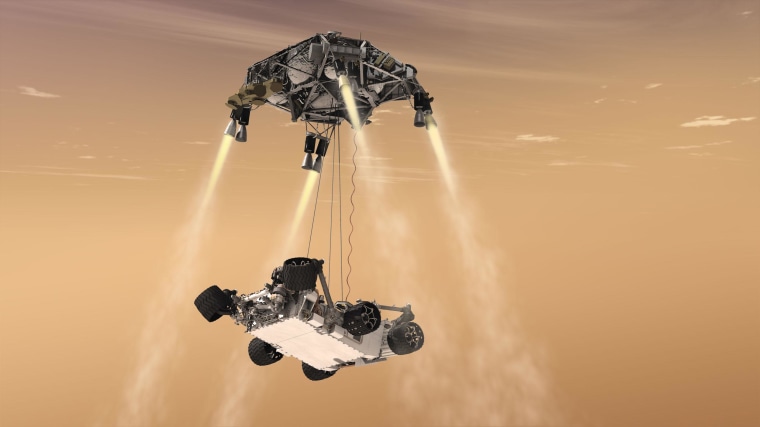 The Sky Crane is shown in aerial ballet mode during the descent of NASA’s Curiosity rover to the Martian surface.