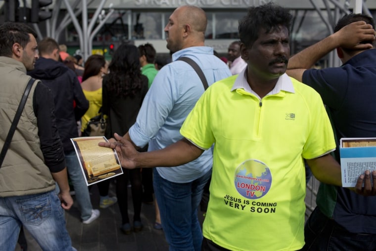 Image: With bibles in one hand and flyers in the other, preacher Jeyamani Rayappan works to get his message out to the tens of thousands of people traveling in and out of Olympic Park